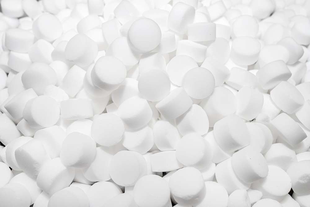 Background made of salt tablets for a water softener, large round cubes.